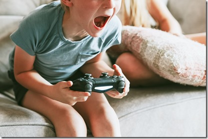 Young boy playing video game in living room