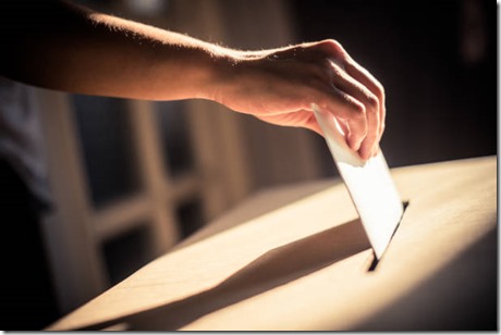Conceptual image of a person voting, casting a ballot at a polling station, during elections.