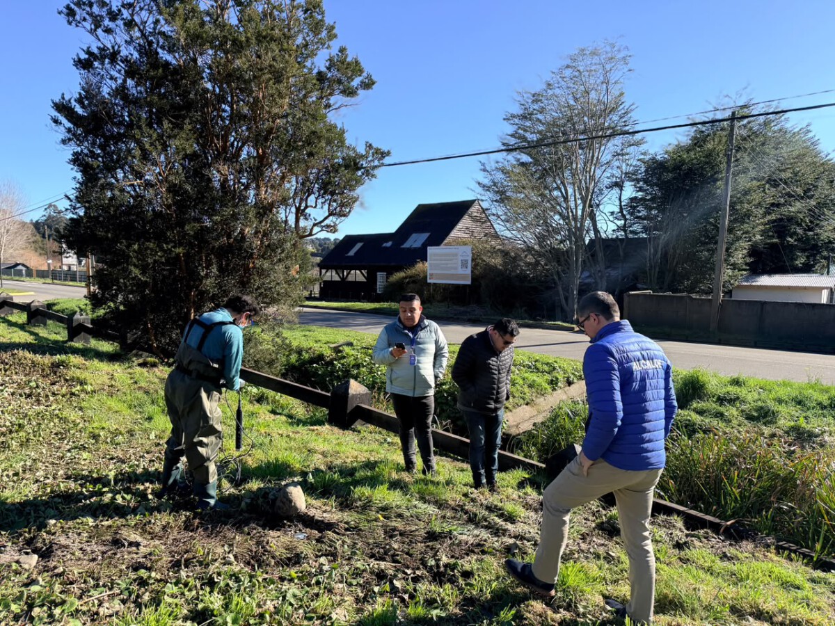 Autoridades realizando muestreo de agua en estero de Frutillar tras denuncia de vertimiento ilegal