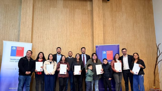 Autoridades municipales y beneficiarios en la entrega de escrituras en Frutillar
