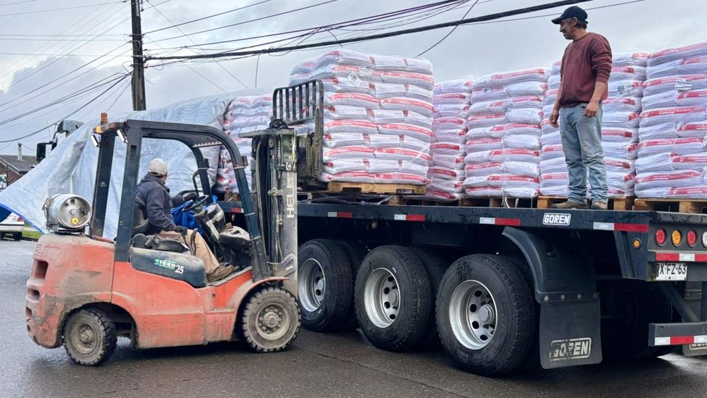 Autoridades del Ministerio de Agricultura supervisan la entrega de sacos de alimento concentrado para ganado en la provincia de Osorno.