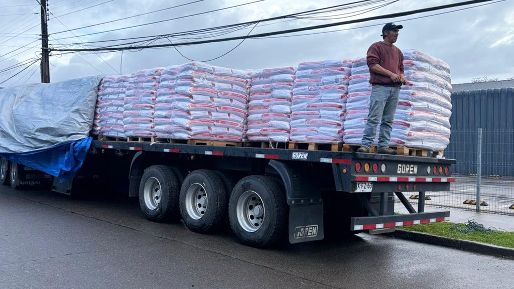 Autoridades del Ministerio de Agricultura supervisan la entrega de sacos de alimento concentrado para ganado en la provincia de Osorno.
