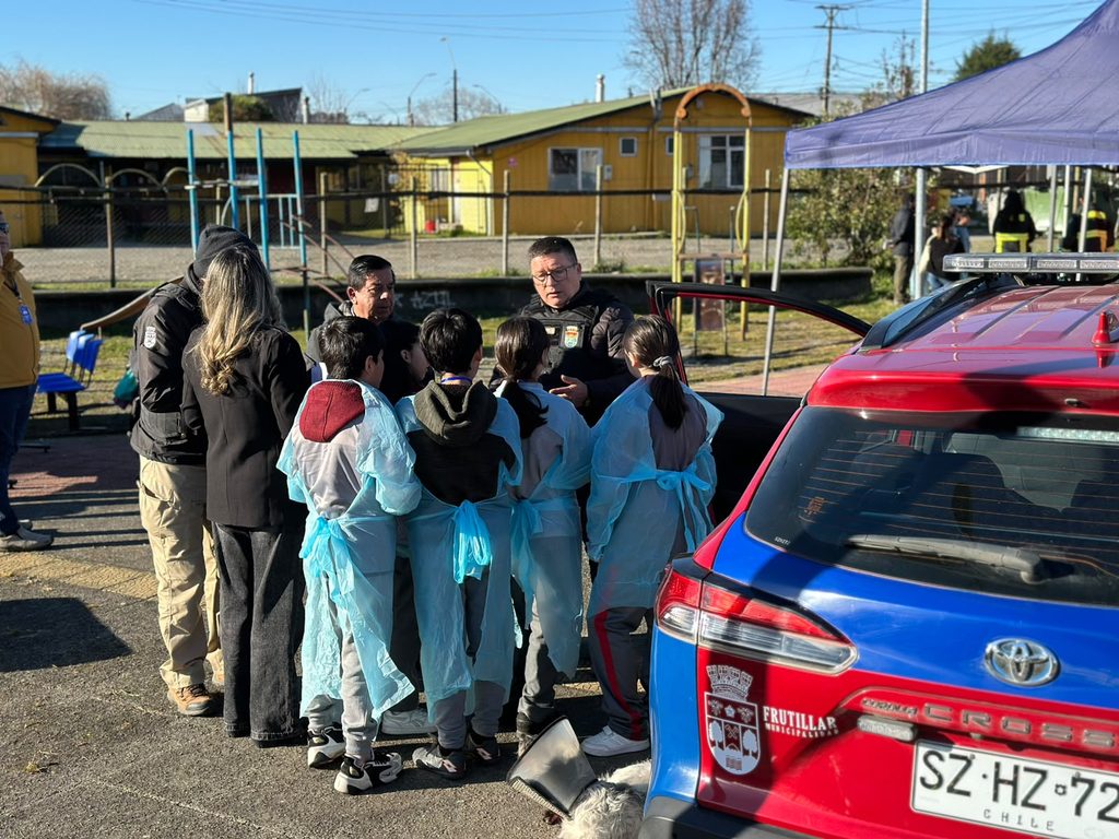 Estudiantes de escuela básica participando en actividades educativas sobre salud y servicios de emergencia en Frutillar