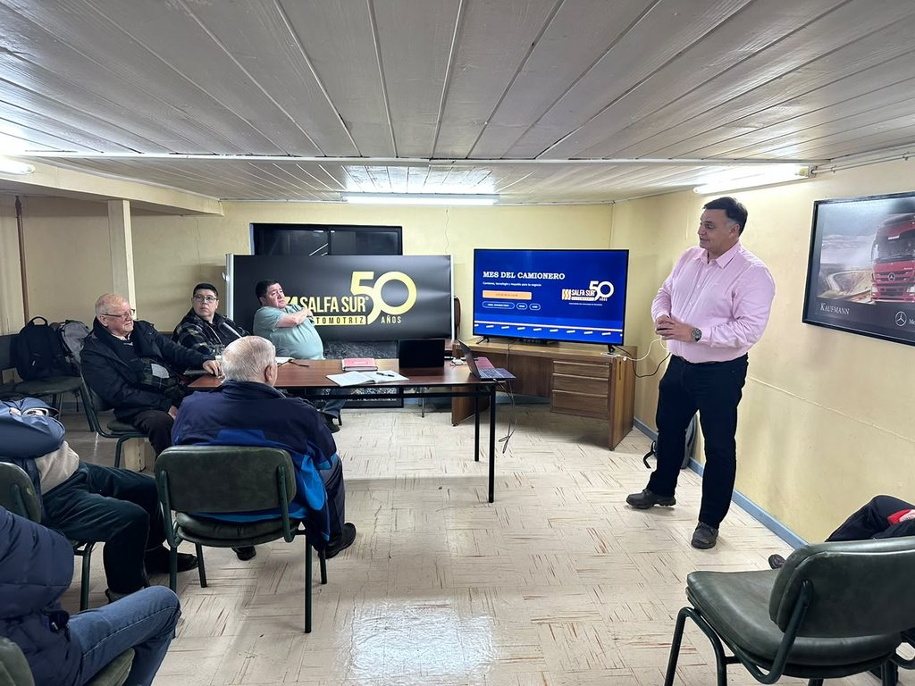 Representantes del gremio de camioneros de Osorno junto a modelos de camiones durante el Día del Camionero