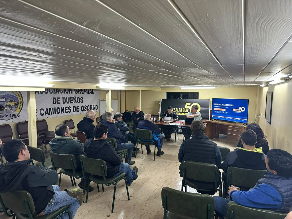 Representantes del gremio de camioneros de Osorno junto a modelos de camiones durante el Día del Camionero