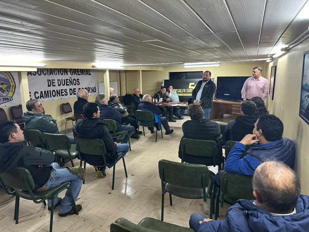 Representantes del gremio de camioneros de Osorno junto a modelos de camiones durante el Día del Camionero