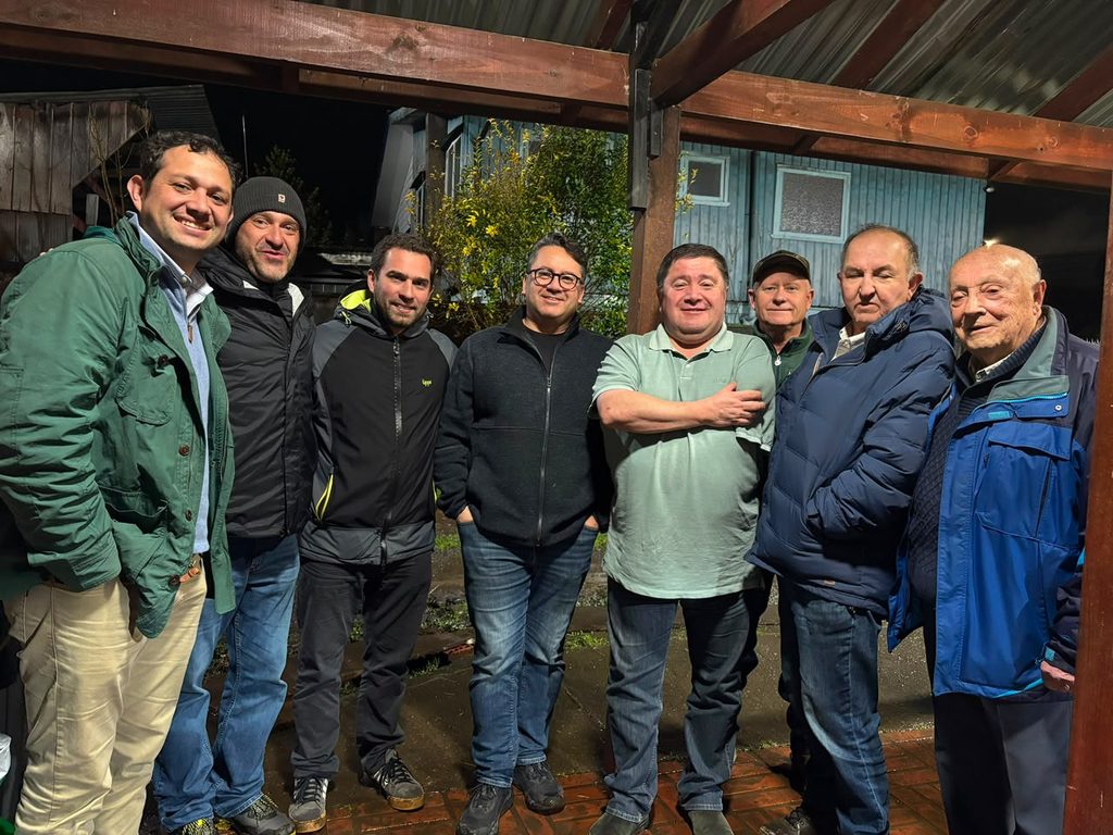 Representantes del gremio de camioneros de Osorno junto a modelos de camiones durante el Día del Camionero