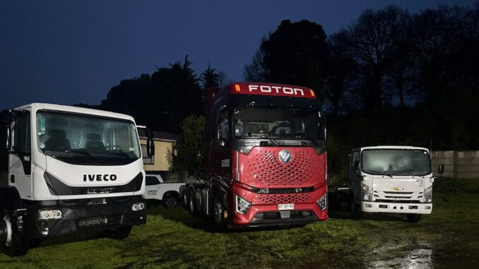 Representantes del gremio de camioneros de Osorno junto a modelos de camiones durante el Día del Camionero