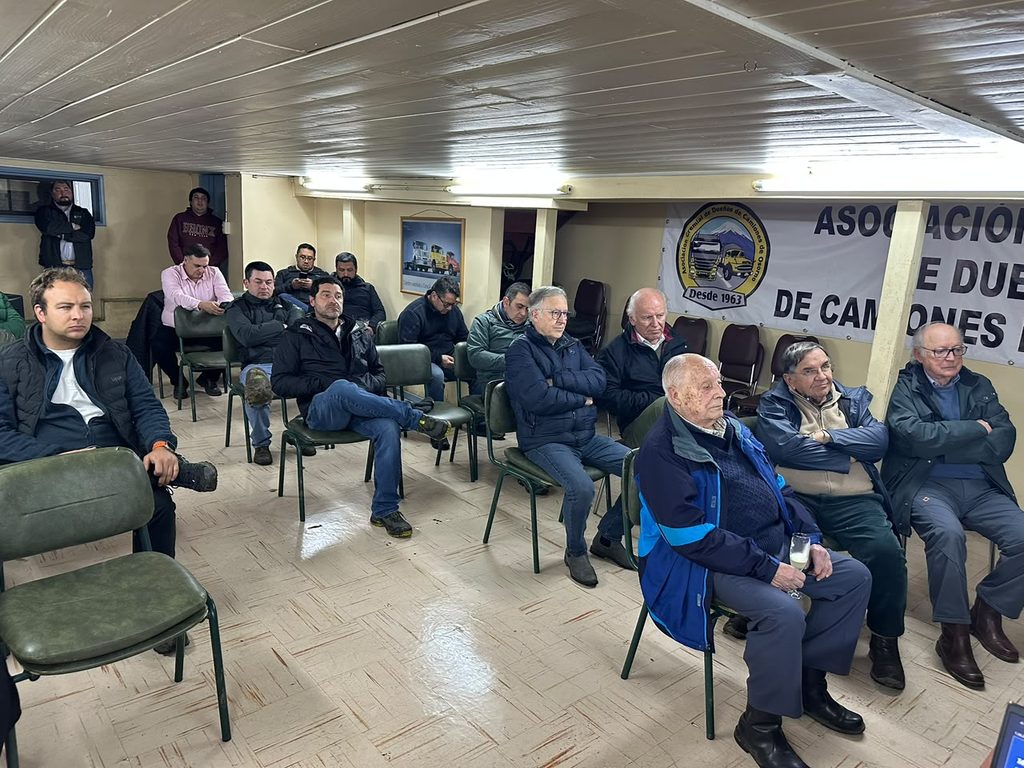 Representantes del gremio de camioneros de Osorno junto a modelos de camiones durante el Día del Camionero