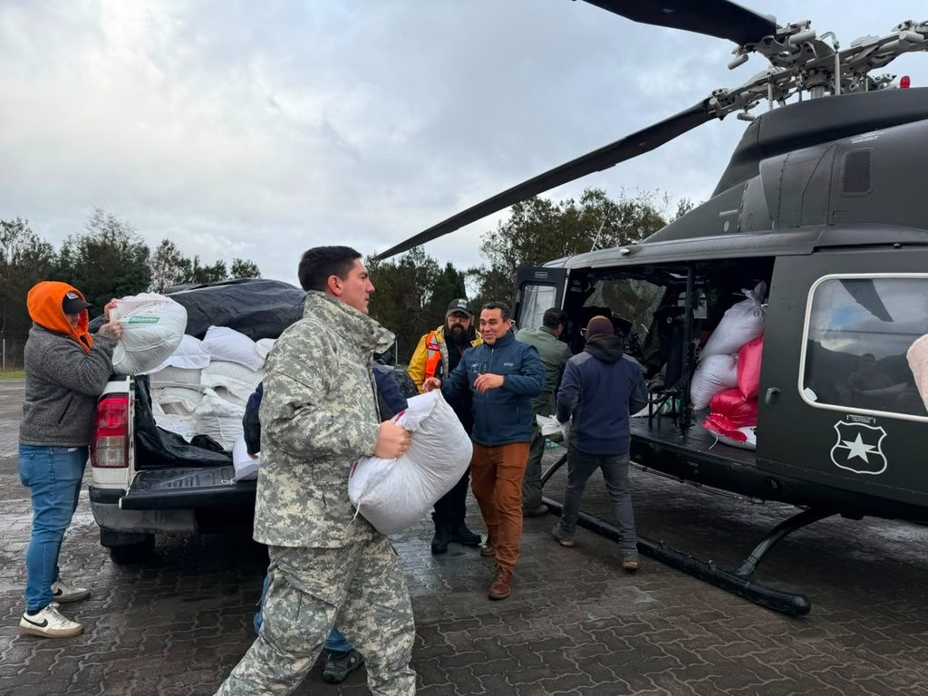 Helicóptero de la FACH transportando alimento para ganado a familias de Cochamó