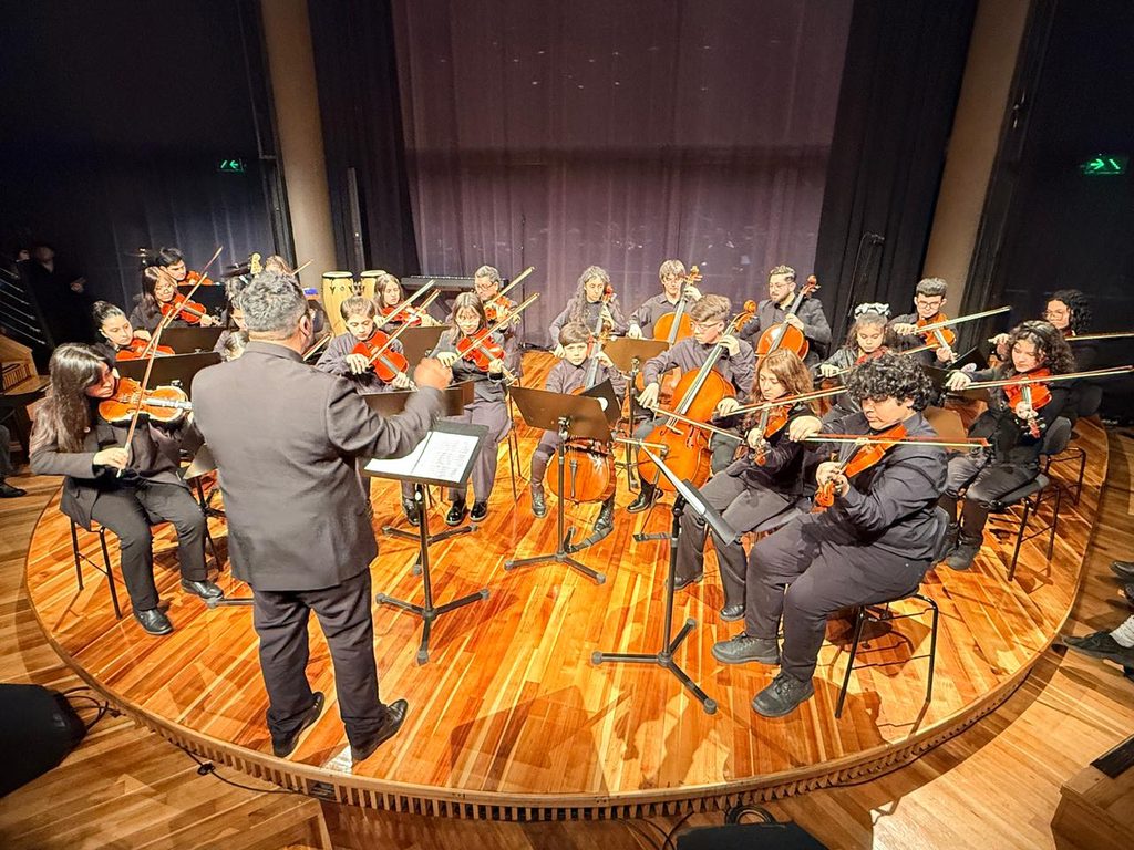 Estudiantes y músicos de la Casa Municipal de la Música durante su presentación en el Teatro del Lago de Frutillar.