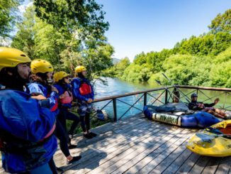 Personas practicando rafting y turismo aventura en un río