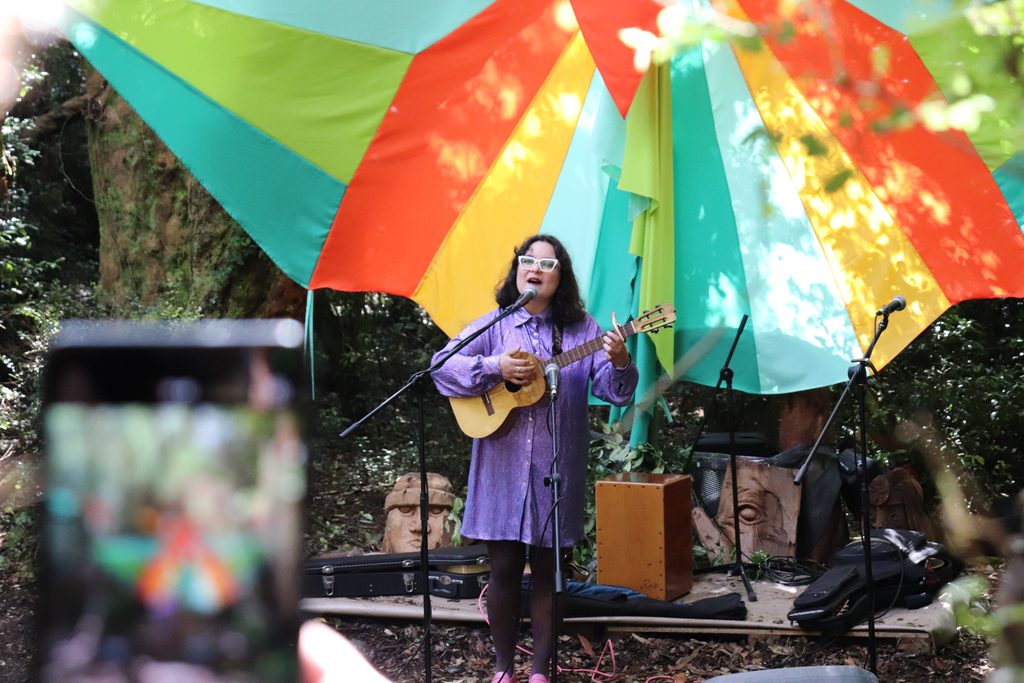 Familias disfrutando de un concierto al aire libre en un bosque de arrayanes durante el festival Chercán