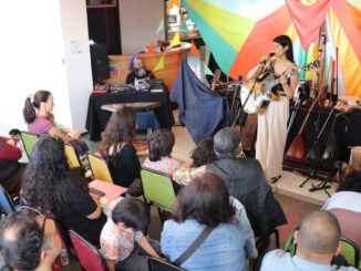Familias disfrutando de un concierto al aire libre en un bosque de arrayanes durante el festival Chercán