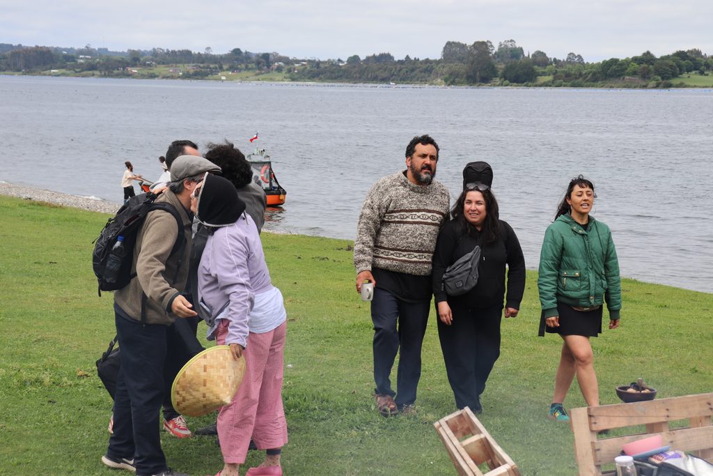 Familias disfrutando de un concierto al aire libre en un bosque de arrayanes durante el festival Chercán
