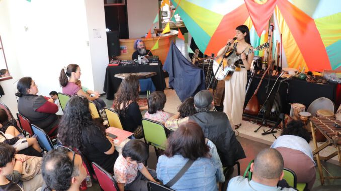 Familias disfrutando de un concierto al aire libre en un bosque de arrayanes durante el festival Chercán
