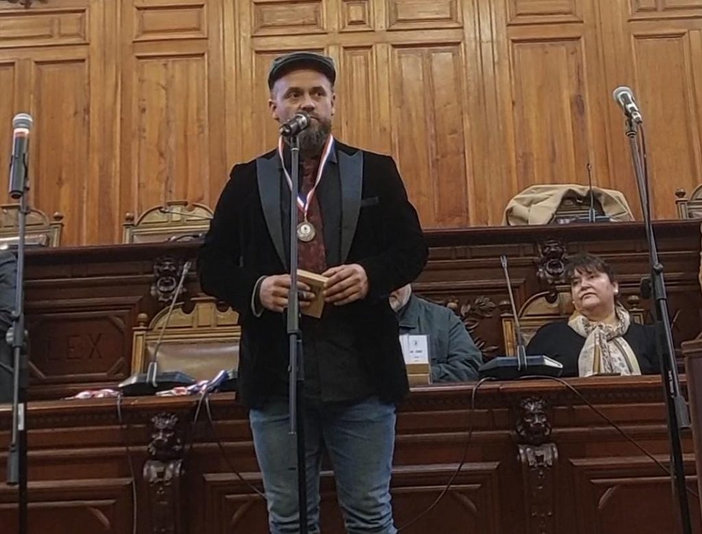 El cantautor osornino Gabriel Guzmán recibiendo reconocimiento por su trayectoria musical y educativa en Santiago.