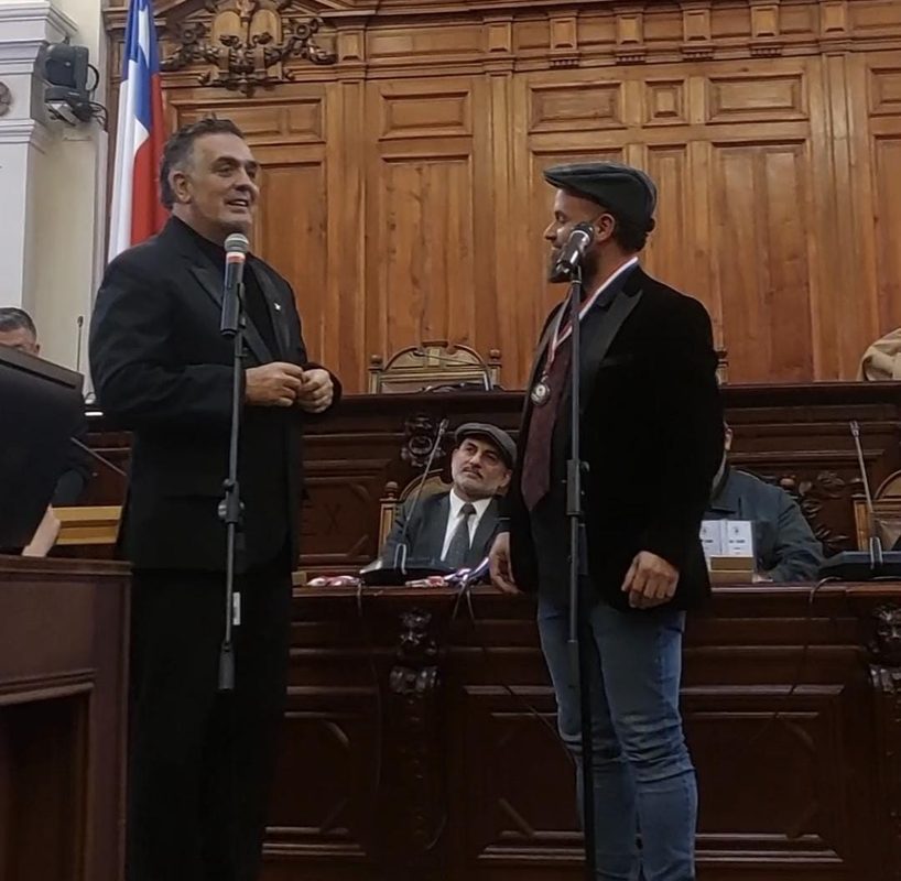 El cantautor osornino Gabriel Guzmán recibiendo reconocimiento por su trayectoria musical y educativa en Santiago.