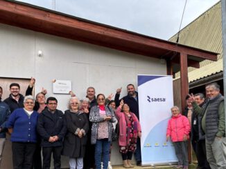 Vecinos y dirigentes participan en la inauguración de la nueva iluminación LED en la sede comunitaria de Bahía Mansa junto a ejecutivos de Saesa.