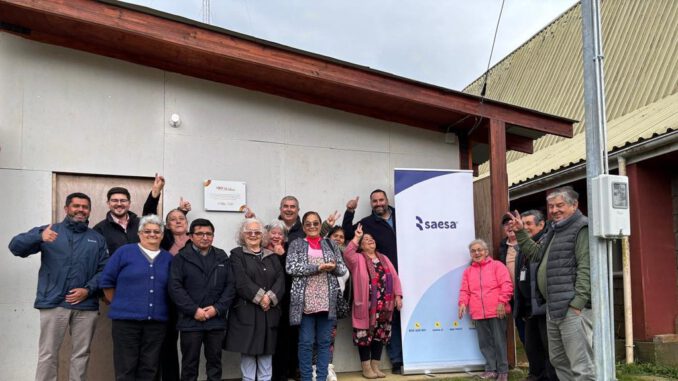 Vecinos y dirigentes participan en la inauguración de la nueva iluminación LED en la sede comunitaria de Bahía Mansa junto a ejecutivos de Saesa.